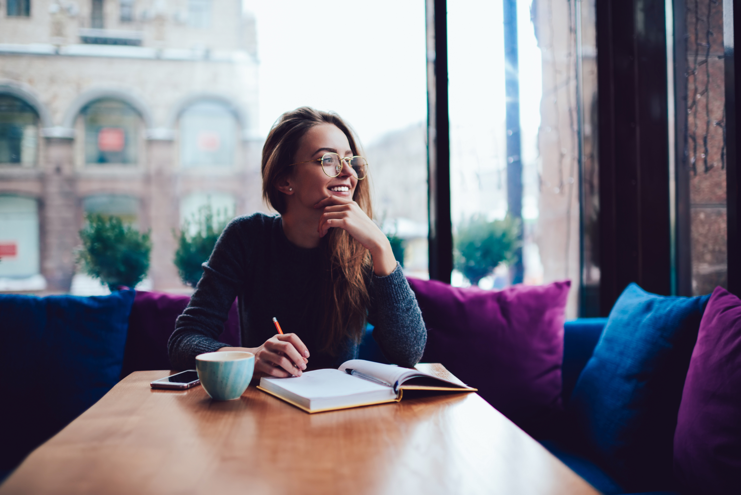 Positive,Young,Woman,In,Stylish,Eyeglasses,Dreaming,While,Sitting,At